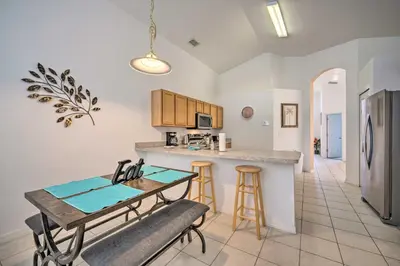 a kitchen and dining room with a table and a counter at Pool and Lanai Emerald Isle Resort Home! in Kissimmee