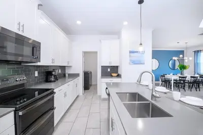 a kitchen with white cabinets and a counter top at Bright & Airy 5BR Resort Home with Pool in Kissimmee