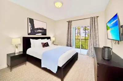 a bedroom with a bed and a large window at Near Disney - Spacious 3BR Condo with Pool in Orlando