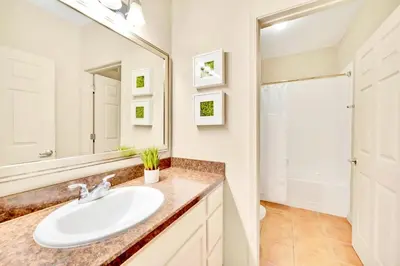 a bathroom with a sink and a mirror at Near Disney - Spacious 3BR Condo with Pool in Orlando