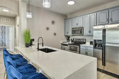 a kitchen with white cabinets and a sink and a refrigerator at Vista Cay Resort Condo about 5 Mi to Universal! in Orlando