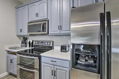 a kitchen with white cabinets and a stainless steel refrigerator at Vista Cay Resort Condo about 5 Mi to Universal! in Orlando
