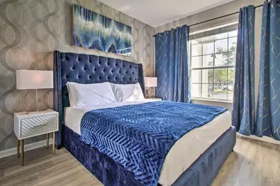 a blue bed in a bedroom with blue curtains at Vista Cay Resort Condo about 5 Mi to Universal! in Orlando