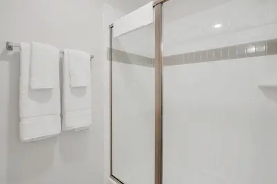 a glass shower in a bathroom with white towels at Newly Renovated Condo wFREE Resort Access in Orlando