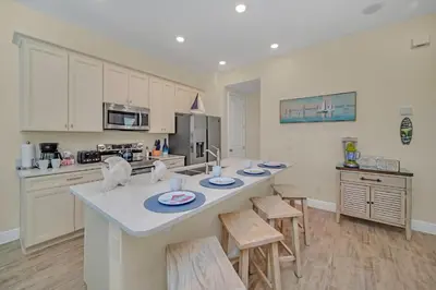 a kitchen with a large island with chairs in it at 2914 Salted Rim Road in Orlando