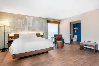 a bedroom with a bed and a desk and a chair at Cambria Hotel Orlando near Universal Theme Parks in Orlando