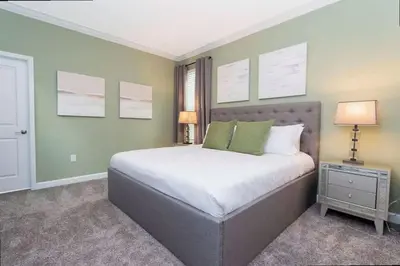a bedroom with a large bed with green walls at Stunning Family Friendly 5 Bd w/ Pool Close to Disney @ Storey Lake 4242 in Kissimmee