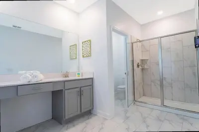 a bathroom with a sink and a glass shower at Stunning Family Friendly 5 Bd w/ Pool Close to Disney @ Storey Lake 4242 in Kissimmee