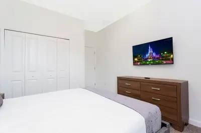 a bedroom with a bed and a tv on the wall at Stunning Family Friendly 5 Bd w/ Pool Close to Disney @ Storey Lake 4242 in Kissimmee