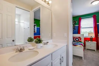 a bathroom with two sinks and a large mirror at Darth's Manor 9 Bed 6 Bath Huge Home Solara Resort villa in Orlando