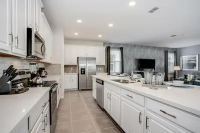 a large kitchen with white cabinets and a refrigerator at Darth's Manor 9 Bed 6 Bath Huge Home Solara Resort villa in Orlando