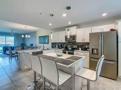 a kitchen with white cabinets and a table and chairs at Last minute deal! Brand New 2bed apt near Disney in Kissimmee
