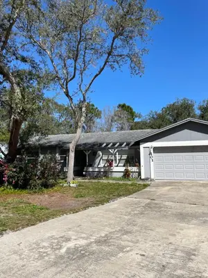 a house with a white garage and a tree at Sanford Lake Mary Quiet Rooms in Sanford