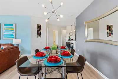 a dining room and living room with a table and chairs at Vista Cay at Epic Universe - Luxury 4 bedroom penthouse in Orlando