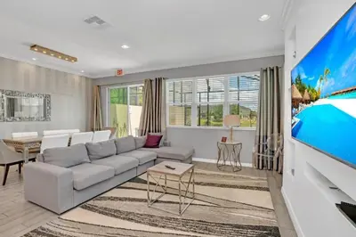 a living room with a couch and a tv at 4 Bed townhome with Private Pool Near Disney! townhouse in Kissimmee