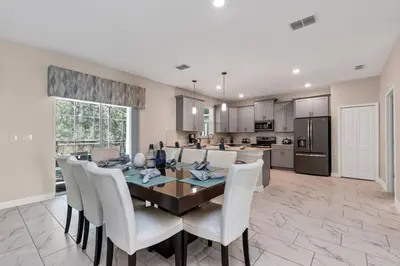 a kitchen and dining room with a table and chairs at Monopoly Fun Storey Lake Resort 6 Bed Star Home! villa in Kissimmee
