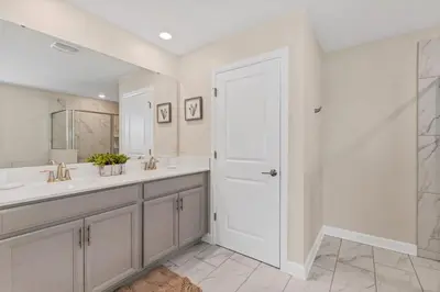 a white bathroom with two sinks and a mirror at Monopoly Fun Storey Lake Resort 6 Bed Star Home! villa in Kissimmee