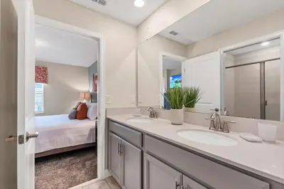 a bathroom with two sinks and a bedroom at Monopoly Fun Storey Lake Resort 6 Bed Star Home! villa in Kissimmee