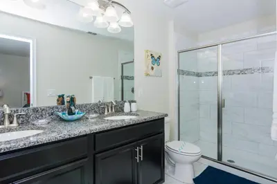 a bathroom with two sinks and a shower at Enchanting Decor Home with private pool in Kissimmee