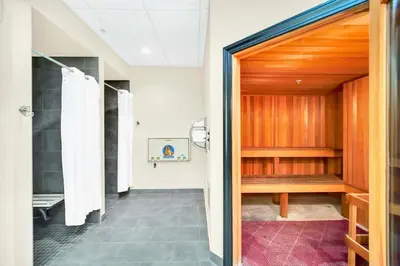 a bathroom with a walk in shower and a wooden door at Relaxing 3BR Near Disney - Pool in Orlando