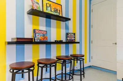 a bar with three stools against a striped wall at Encore Resort 5 Bedroom Home with Pool 2201 in Orlando