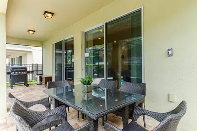 a glass table and chairs on a patio at Encore Resort 5 Bedroom Home with Pool 2201 in Orlando