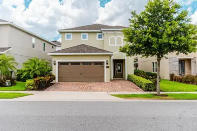 a house with a garage and a tree at Encore Resort 5 Bedroom Home with Pool 2201 in Orlando