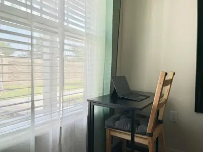a laptop computer sitting on a desk next to a window at Super Comfy and Spacious 3 Bedroom 15-20 minutes from Disney, with major shopping 4 minutes away in Kissimmee