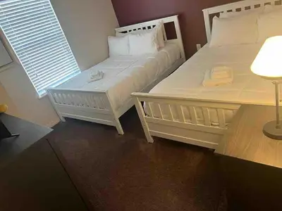 two white beds in a room with a window at Super Comfy and Spacious 3 Bedroom 15-20 minutes from Disney, with major shopping 4 minutes away in Kissimmee