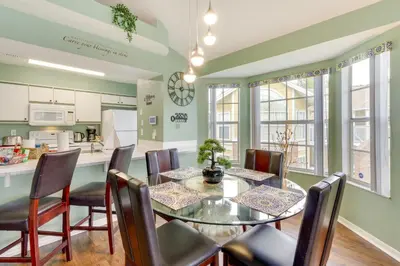 a kitchen and dining room with a table and chairs at Kissimmee Condo with Private Porch Less Than 7 Mi to Disney! in Kissimmee