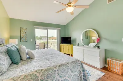 a bedroom with a bed with a ceiling fan and a mirror at Kissimmee Condo with Private Porch Less Than 7 Mi to Disney! in Kissimmee
