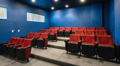an empty auditorium with red chairs and blue walls at Magical 7BR Resort Pool Home Near Disney & Orlando Attractions in Kissimmee