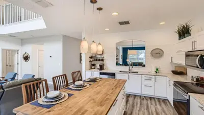 a kitchen and dining room with a wooden table at Magical 7BR Resort Pool Home Near Disney & Orlando Attractions in Kissimmee
