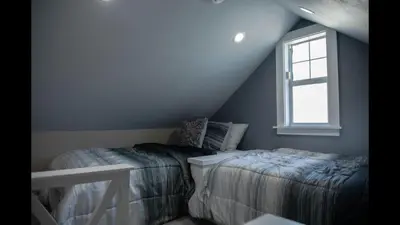 a attic bedroom with two beds and a window at Family Home with Private Pool Yard Only 24 Mi to Disney in Saint Cloud