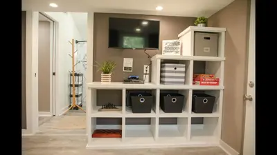 a white book shelf in a hallway with a tv at Family Home with Private Pool Yard Only 24 Mi to Disney in Saint Cloud