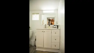 a bathroom with a sink and a toilet and a mirror at Family Home with Private Pool Yard Only 24 Mi to Disney in Saint Cloud