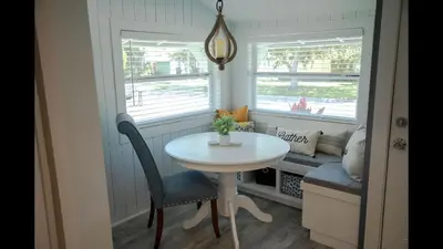 a small white table and chair in a room with windows at Family Home with Private Pool Yard Only 24 Mi to Disney in Saint Cloud