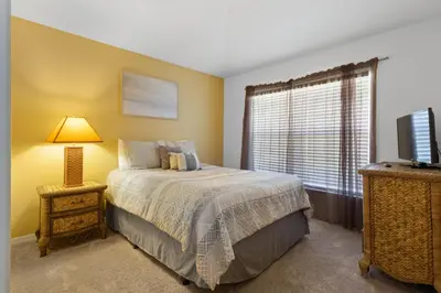 a bedroom with a bed with a lamp and a window at Family Oasis 5BR Villa with South Facing Pool and Games Room Near Disney in Kissimmee