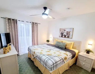 a bedroom with a bed and a flat screen tv at JC DISNEY House in Kissimmee