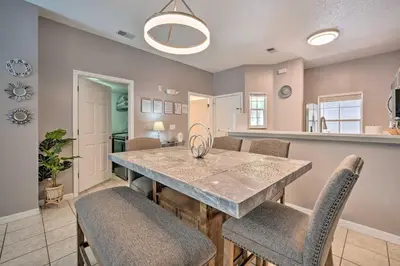 a kitchen and dining room with a table and chairs at 9 Mi to Disney Resort Getaway with Private Patio! in Kissimmee