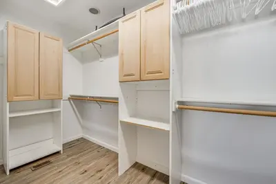 a walk in closet with white cabinets and wood floors at Lakefront Retreat with Kayaks and Fire Pit in Clermont in Clermont