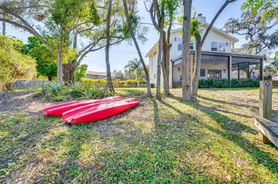 two red kayaks on the grass in front of a house at Lakefront Retreat with Kayaks and Fire Pit in Clermont in Clermont