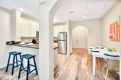 a kitchen and dining room with a table and chairs at 3BR Condo with Pool - Near Disney in Orlando