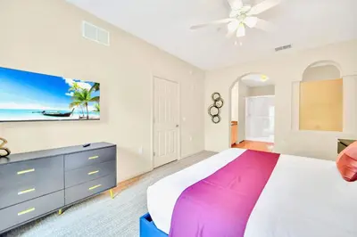 a bedroom with a large bed and a ceiling fan at 3BR Condo with Pool - Near Disney in Orlando