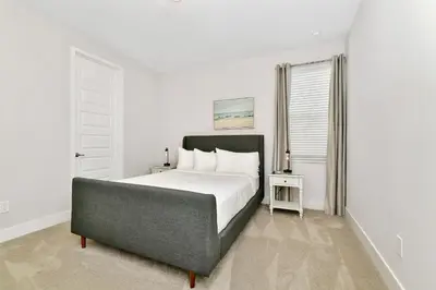 a white bedroom with a large bed and a window at Modern Home Near Disney With Private Pool And Waterpark & Resort Access At Encore Resorts Reunion - 393Sf in Kissimmee