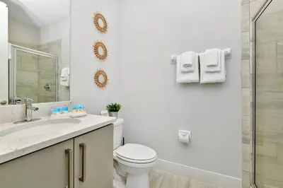 a white bathroom with a toilet and a sink at Modern Home Near Disney With Private Pool And Waterpark & Resort Access At Encore Resorts Reunion - 393Sf in Kissimmee