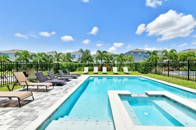 a swimming pool with chaise lounge chairs next to a swimming pool at Modern Home Near Disney With Private Pool And Waterpark & Resort Access At Encore Resorts Reunion - 393Sf in Kissimmee