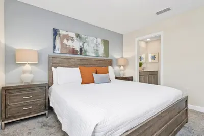 a bedroom with a large bed and two night stands at Delight Indoor Adventure Steps From Disney in Kissimmee