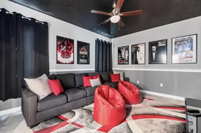 a living room with a couch and a ceiling fan at Delight Indoor Adventure Steps From Disney in Kissimmee