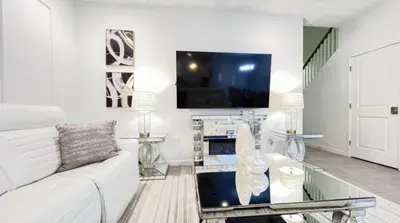 a living room with a white couch and a tv at NEW! Solara Pool Home 6 Miles to Disney in Kissimmee